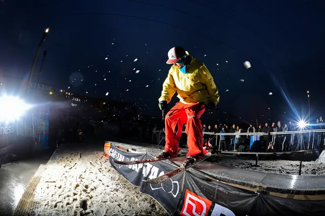 Snowboarder on a rail at night